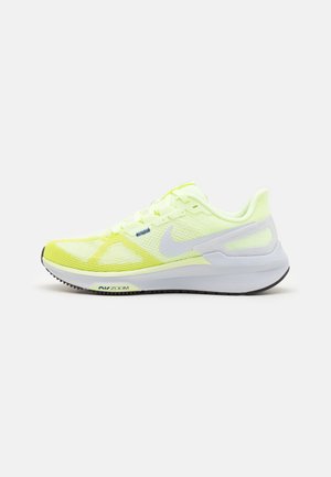 Chaussure de course Nike jaune et blanche avec logo swoosh blanc et semelle noire, vue de côté sur fond blanc.