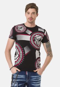 Schwarzes T-Shirt mit kurzen Ärmeln, ausgestattet mit kreisförmigen grafischen Mustern in Grau und Rot, das ein auffälliges Design und einen glatten Baumwollstoff aufweist.