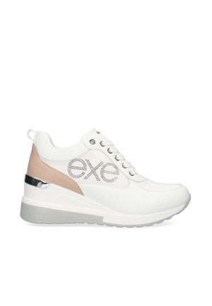 Zapatilla blanca con un diseño elegante, con detalles en plata, un panel en rosa pálido y un logo texturizado. Suela elevada para mayor altura.