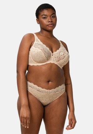 Set de lencería de encaje beige que incluye un sujetador con borde festoneado y bragas a juego con patrones florales y una textura suave.