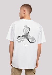 White cotton T-shirt featuring a large black abstract graphic design on the back, with a relaxed fit and short sleeves.