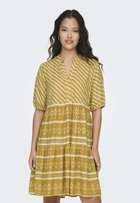 Gelbes Kleid mit vertikalen Streifen und geometrischen Mustern. Hat einen V-Ausschnitt und kurze Puffärmel. Ausgestellter, gestufter Schnitt.