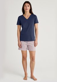 Marineblauw V-hals t-shirt van zachte stof, gecombineerd met pastelpink gestreepte shorts. Het shirt heeft korte mouwen en de shorts hebben verticale strepen.