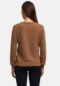 Maglione lavorato a maglia marrone con un collo rotondo, polsini e orlo a coste. Tessuto testurizzato visibile sul retro. Nessun motivo o accessorio visibile.