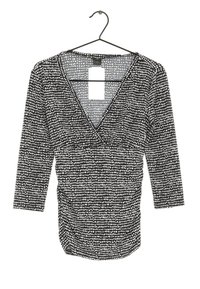 Svart och vitmönstrad topp med V-ringning, trekvartsärmar och insamlad sidodetaljering. Tillverkad av ett slätt, lättviktsmaterial.