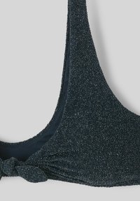 Haut de bikini noir avec une finition texturée et scintillante. Caractéristiques d'un accent en noeud à l'avant et de bretelles réglables. Le matériau est extensible et doux.