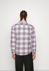 Lila-weiß kariertes Hemd mit langen Ärmeln, geknöpften Manschetten und geradem Saum, aus einem strukturierten Stoff gefertigt. Rückansicht dargestellt.