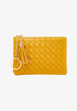 Žlutá kožená peněženka s tkanou strukturou, s kovovým zipem, třásní jako doplňkem a kovovým kroužkem připojeným k řetízku.