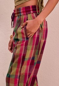 Farebné nohavice s potlačou so vzorom káro v ružovej, zelenej a fialovej farbe, s elastickým pásom a bočnými vreckami.