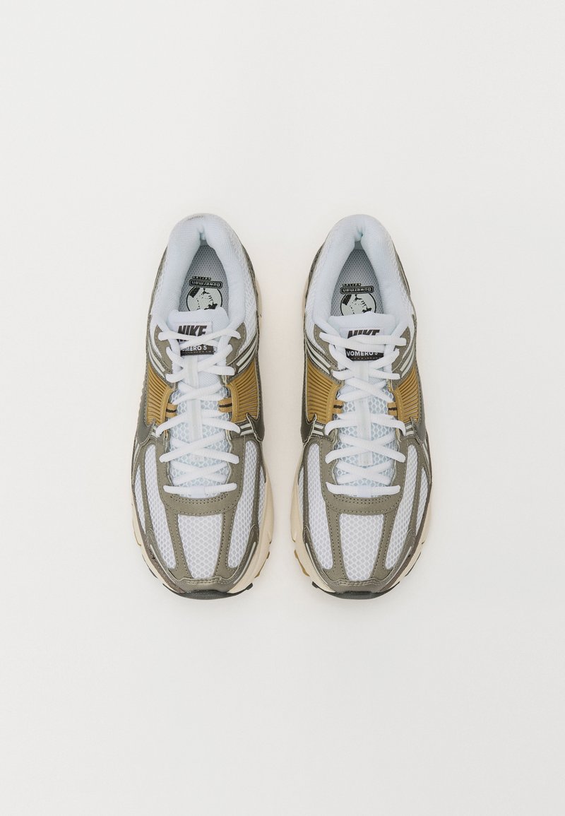 Nike Vomero Sneakers mit einem weißen Mesh-Obermaterial, olivgrünen Akzenten und reflektierenden Details. Verfügt über flache weiße Schnürsenkel und eine gepolsterte Zunge.