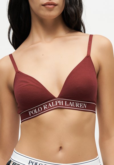 Γυναίκα που φοράει μπορντό τριγωνικό bralette με λεπτές τιράντες και λευκή ζώνη με το λογότυπο Polo Ralph Lauren κάτω από το στήθος.