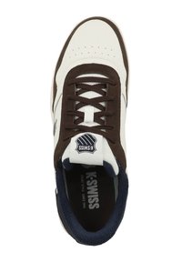 White and brown sneaker with textured suede accents, perforated leather, brown laces, and a navy blue collar. Features a logo on the tongue.