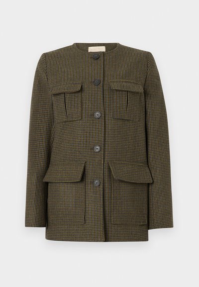 Chaqueta de cuadros marrones con cuatro bolsillos frontales, cuello redondo y tres botones negros. Fabricada con una tela texturizada y un ajuste estructurado.