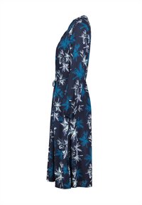 Navy-sininen mekko, jossa on turkoosi- ja valkopohjainen kukkakuosi. Mekossa on vyöllinen vyötärö, pitkät hihat ja soljuva siluetti.