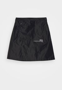 Jupe noire en matière lisse et légère, dotée de deux poches latérales, d'accents à boutons, et d'un logo imprimé sur le bas devant.