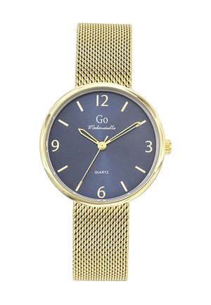 Montre-bracelet avec bracelet en maille dorée, cadran bleu foncé, index et aiguilles dorés, affichant l'heure à 10:10:35, modèle quartz de la marque "Go Mademoiselle".