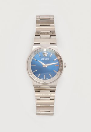 Orologio da polso Versace in metallo argentato con quadrante blu, indici argentati e logo Medusa alle 12, cinturino metallico a maglie inciso con la scritta Versace.