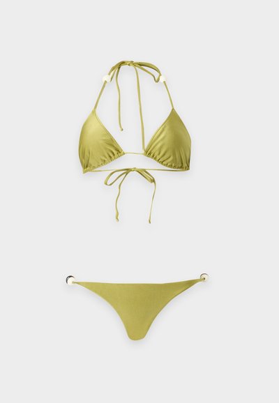 Bikini deux pièces triangulaire vert olive avec liens au cou et détails anneaux métalliques sur le bas du bikini sur fond blanc.