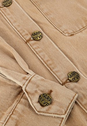 Beige spijkerjack met een bruine stiksels en ronde metalen knopen met de gravure "HARPER & YVE."