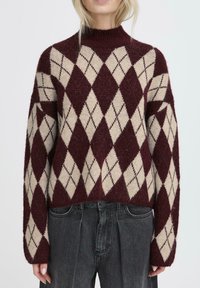 Maggione e beige pullover con motivo argyle e collo alto, realizzato in morbido tessuto a maglia. Presenta maniche ampie e una vestibilità comoda.