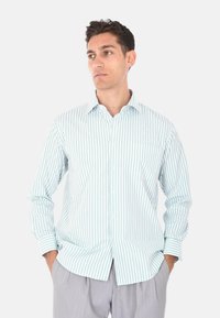 Camicia button-up a righe blu chiaro e bianco, con tasca, maniche lunghe e vestibilità rilassata. Tessuto di cotone con una consistenza liscia.