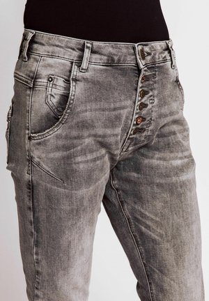 Graue Denim-Hosen mit einem ausgewaschenen Finish, ausgestattet mit einem Knopfverschluss vorne und mehreren Taschen an den Seiten.