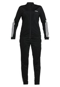 Survêtement noir à fermeture éclair intégrale avec logo Adidas blanc sur la poitrine et trois bandes blanches le long des manches et des côtés du pantalon.