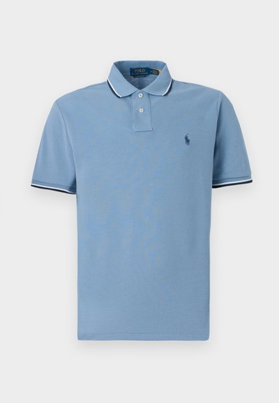 Svetlo modra polo majica s ovratnikom, dvema gumboma, belimi in mornarskimi črtami na rokavih ter majhnim logotipom.