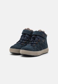 Chaussures mi-hautes en velours bleu avec des côtés texturés, accents marron, doublure en fausse fourrure, sangle ajustable et semelle en caoutchouc avec motif d'adhérence.