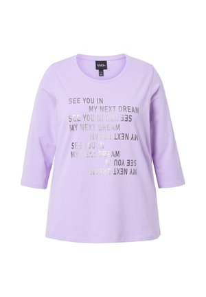 T-shirt lavanda con maniche a tre quarti, caratterizzato da testo riflettente argento "CI VEDIAMO NEL MIO PROSSIMO SOGNO" in un motivo ripetitivo sulla parte frontale.