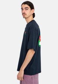 Camiseta de algodón azul marino con mangas cortas y cuello redondo, que presenta estampados florales coloridos en el pecho y la espalda.