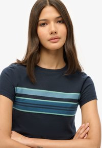 Marineblauw t-shirt met horizontale strepen in tinten blauw en groen. Korte mouwen en een ronde hals, gemaakt van zachte stof met een gladde textuur.