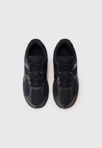 Chaussures de sport noires en matériaux synthétiques et en maille, à bout rond, à lacets, avec une semelle texturée pour une bonne adhérence.