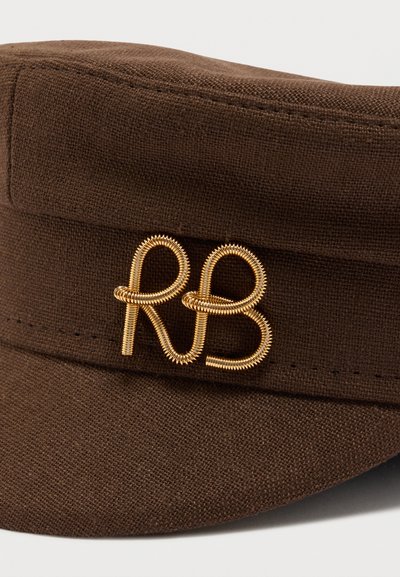 Καφέ υφασμάτινο καπέλο με καμπύλη γείσο που φέρει ένα χρυσό καρφίτσα σε σχήμα γραμμής με τα γράμματα "RB" στο μπροστινό μέρος.