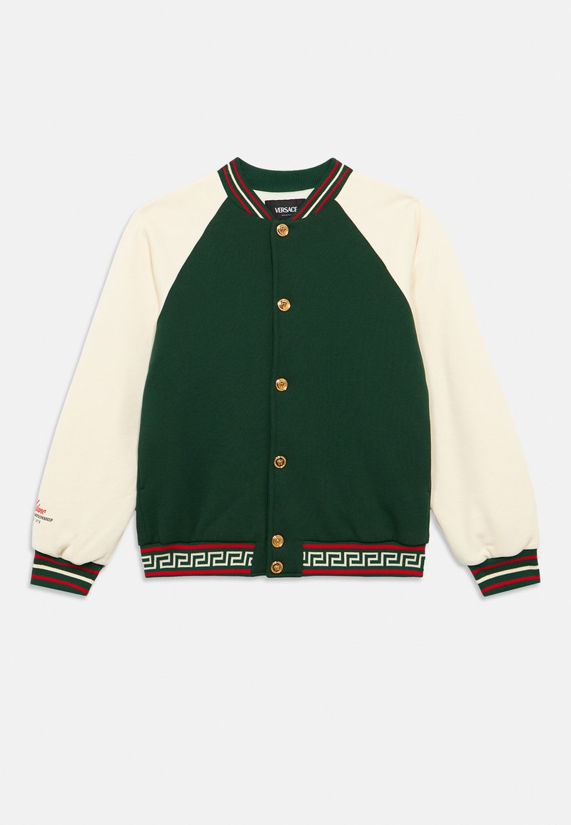 Πράσινο και κρεμ μπουφάν varsity με χρυσά κουμπιά, ριμπ κολάρο και μανσέτες, και σχέδιο ελληνικού κλειδιού κατά μήκος του τελειώματος σε κόκκινο και πράσινο.