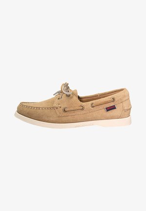 Beige suede boat shoe with lacing detail, rubber sole, and contrasting stitching. Features a small brand logo on the side.