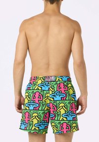 Costumi da bagno da uomo realizzati in un tessuto morbido e leggero, caratterizzati da un motivo colorato con contorni di figure in rosa, blu, giallo e verde.