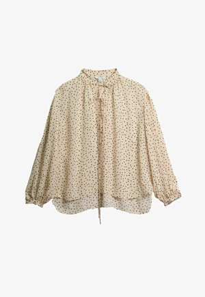 Bež bluza s dugim rukavima s crnim točkicama, naboranim manšetama, visokim ovratnikom i vezicama sprijeda koje se protežu ispod ruba.