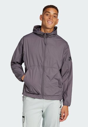 Lätt, grå huvjacka med framdragkedja, elastiska ärmslut och två sidofickor. Har en minimalistisk design och vattentålig finish.