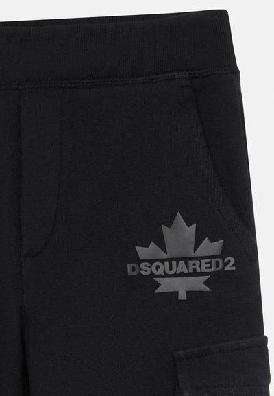 Čierne tepláky vyrobené z mäkkého materiálu, s matným čiernym logom obsahujúcim javorový list a text "DSQUARED2" na ľavom stehne.