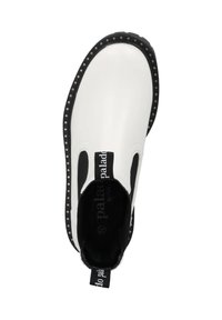 Zapatilla blanca sin cordones con acentos negros, que presenta una superficie texturizada, paneles elásticos en los laterales y un borde negro con puntos. Logotipo visible en el interior.