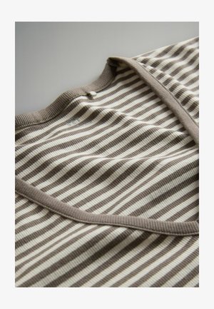 Primo piano di un tessuto a righe beige e bianche con scollatura a costine e dettagli di cucitura su una superficie piana.