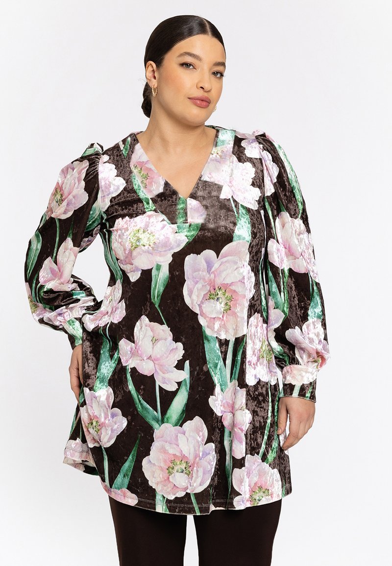 Fluwelen tuniek met een diepe V-hals, gekenmerkt door grote roze bloempatronen op een donkerbruine achtergrond en pofmouwen.
