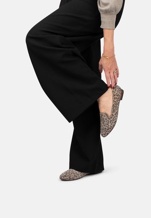 Leopardprint platte schoenen met een ronde neus, zachte textuur en een lage hak, gecombineerd met een zwarte wijde broek.