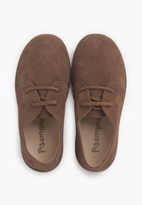 Scarpe in suede marrone con punta arrotondata, dotate di due fori per lacci e suola piatta. L'interno presenta un marchio stampato in un colore a contrasto.