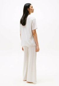 Lysegrå bomulds loungewear sæt bestående af en løs pasform T-shirt med korte ærmer og vidde bukser, glat tekstur, minimalistisk design.