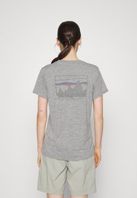 Gray short-sleeve t-shirt featuring a mountain graphic and "Patagonia" text on the back, made from soft, breathable material.