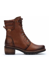 Bottine en cuir marron avec un bout rond, un devant à lacets et des accents texturés. Présente un talon empilé et une semelle robuste pour une meilleure adhérence.