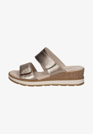 Metallische bronzen slidersandalen met twee brede bandjes, een gestructureerde wigzool en een lichtbeige binnenzool, met een patroon onderkant en witte rand.