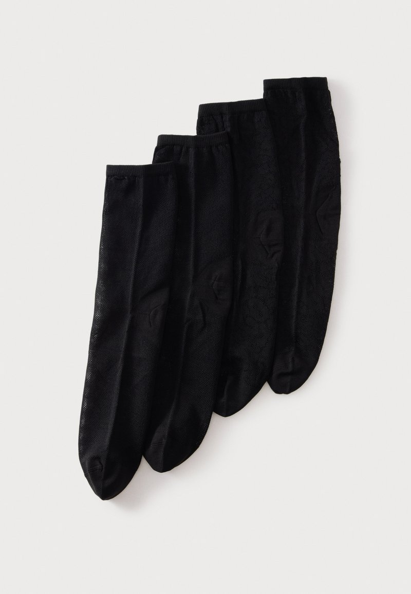 Quatre paires de chaussettes noires pour chevilles superposées en arrangement décalé sur un fond blanc.
